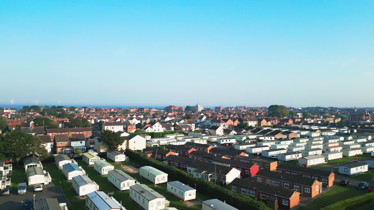 Take a mesmerizing flight over Skegness's holiday parks, featuring caravans, holiday homes, and the surrounding countryside on a summer evening