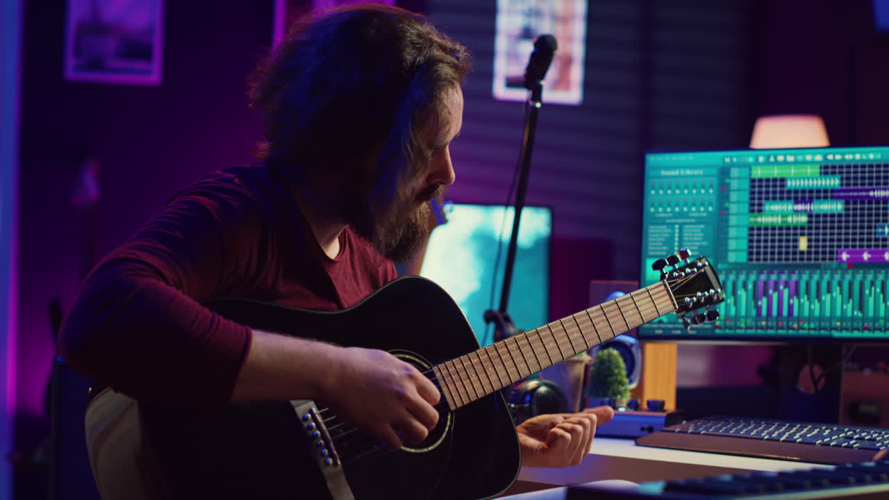 productor de música afinando su guitarra acústica antes de tocar el instrumento,