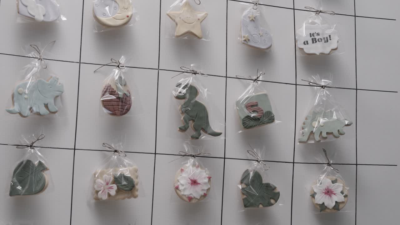 toma en órbita de izquierda a derecha de galletas de cumpleaños hechas a mano personalizadas colgadas en un estante en una pastelería haciendo regalos decorados individualmente, cámara lenta de 4k