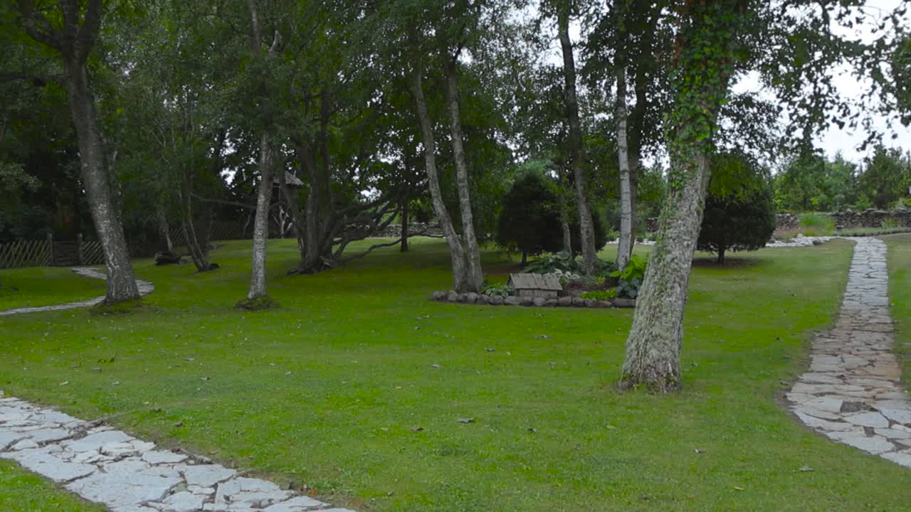 сад, полный старых деревьев, которые имеют изогнутые известняковые дороги, идущие между деревьями