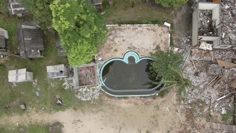 Aerial-birds-eye-view-right-trucking-shot-of-a-abandoned-derelict-destroyed-beach-resort-on-Koh-Chang,-Thailand-from-the-effects-of-covid-19