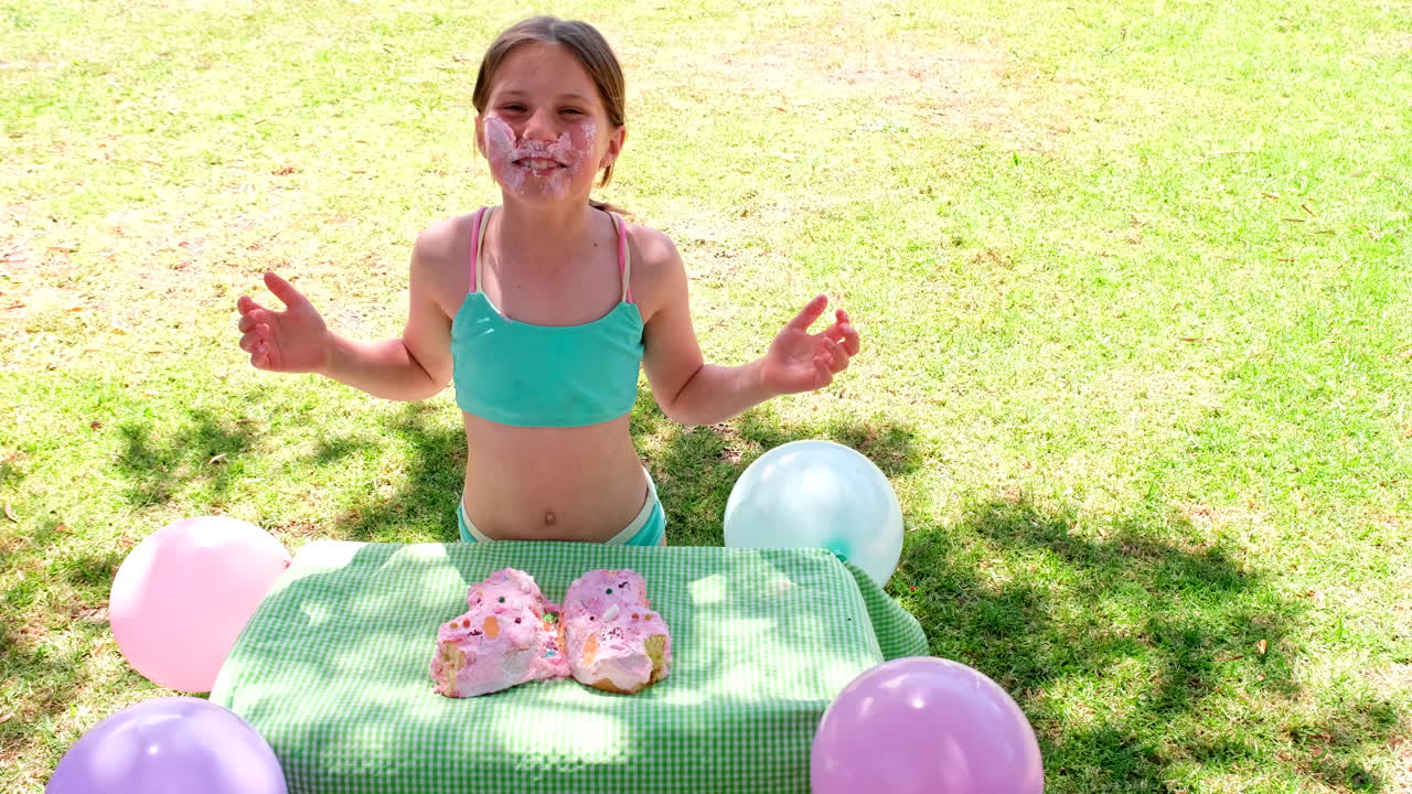 Silly birthday girl in swimsuit push face directly into cake to take bite, slomo