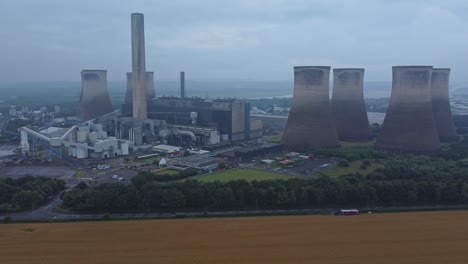 imposing concrete cooling tower power station farmland countryside aerial view high right pan