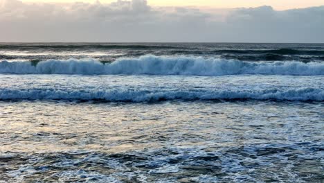 La-Luz-Del-Sol-Dorada-Se-Refleja-En-Las-Tumultuosas-Olas-Del-Océano,-La-Superficie-Del-Mar-Brilla-Al-Atardecer