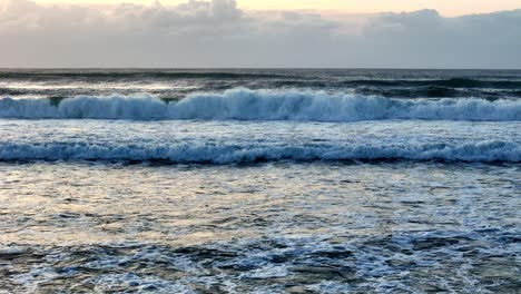 golden sunlight reflecting on tumultuous ocean waves, the sea's surface glistening at sunset