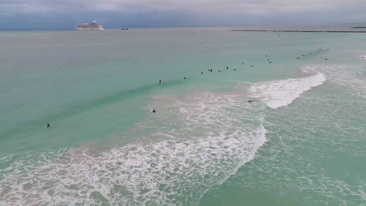 video de drones de personas surfeando en la playa de miami durante el invierno
