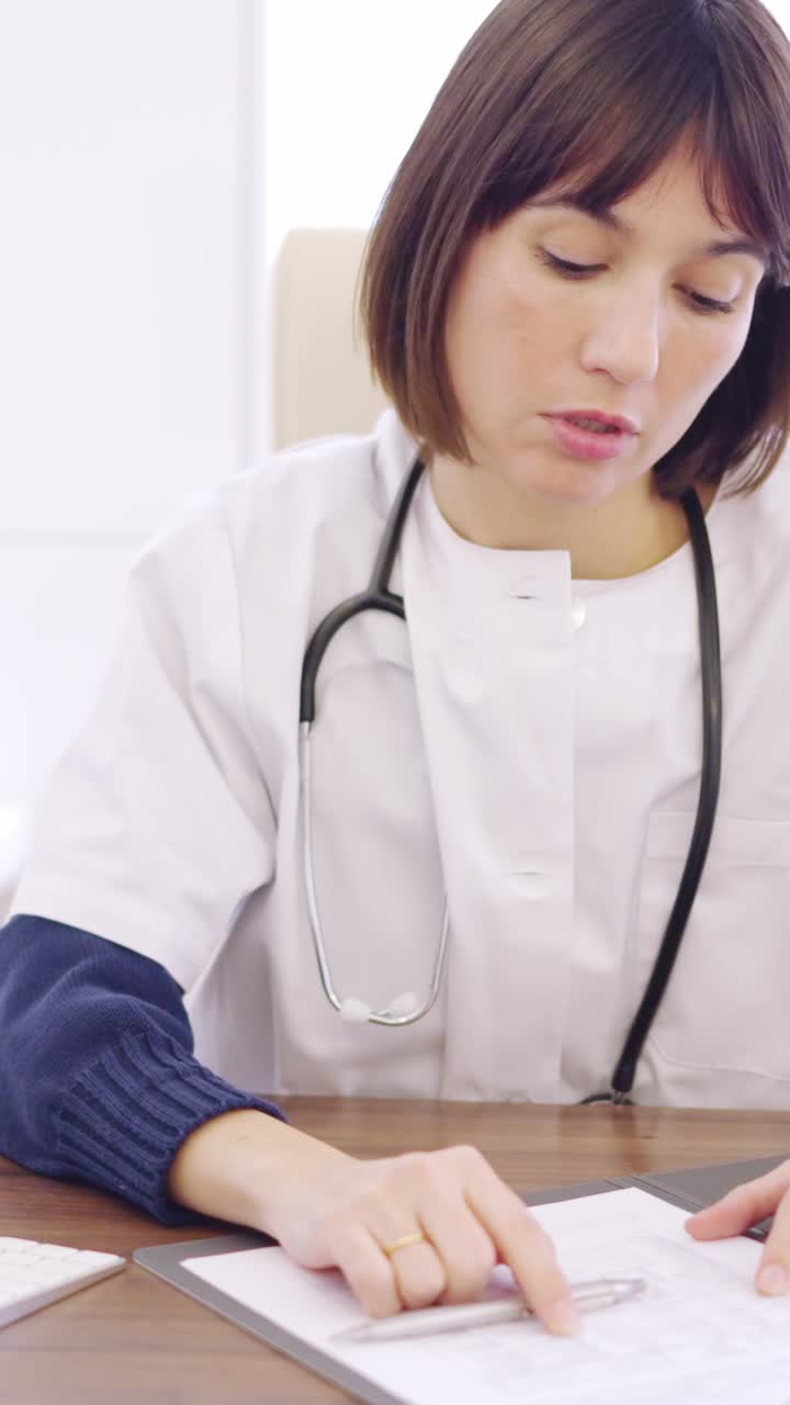 Worried female doctor looking at a computer and medical report