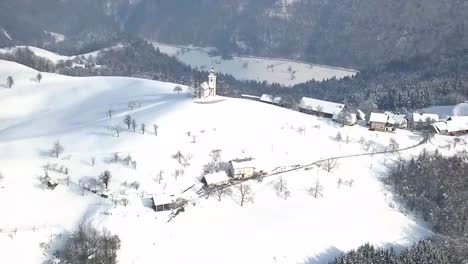 the picturesque church of sveti tomaz on the top of the hill in central slovenia during winter