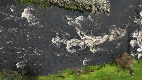 Top-down-aerial-of-rapids-in-flowing-river,-Yorkshire,-United-Kingdom