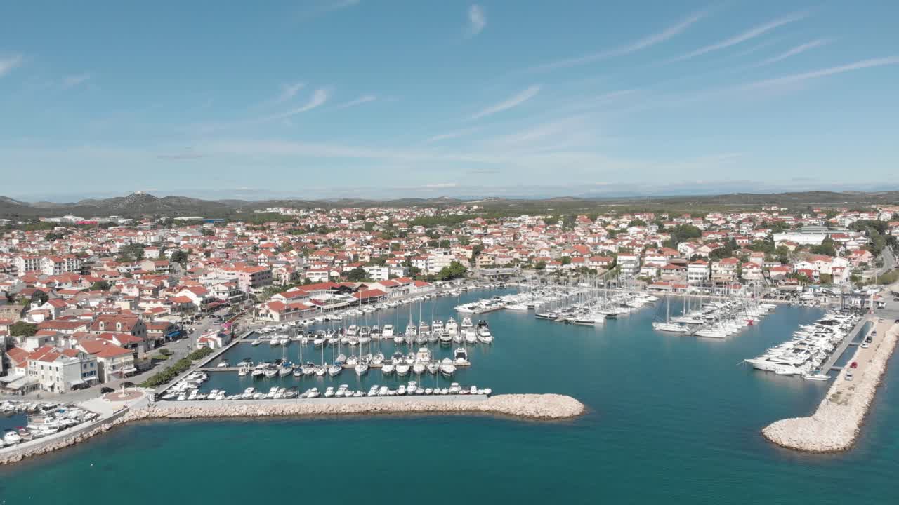 Vista aerea con drone di un porto con yacht ormeggiati sull'acqua e una grande città per il campeggio turistico durante l'estate in Croazia, Europa