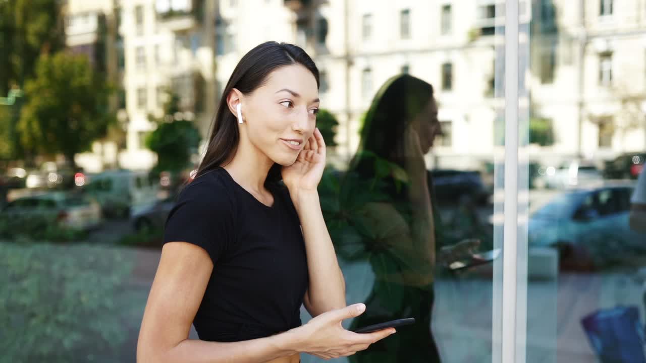 Donna all'aperto con auricolari e smartphone