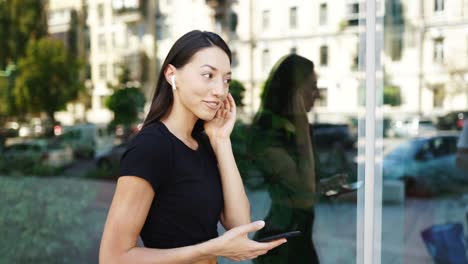 mujer al aire libre con auriculares y teléfono inteligente