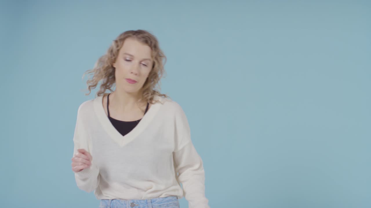 foto de estudio de una joven que se divierte bailando con fondo azul 4