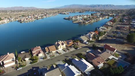 aerial over a suburban neighborhood in the desert with an artificial lake distant 2