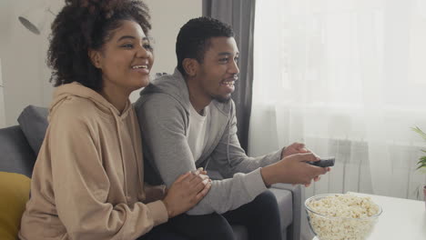 young couple choosing a movie with the remote control