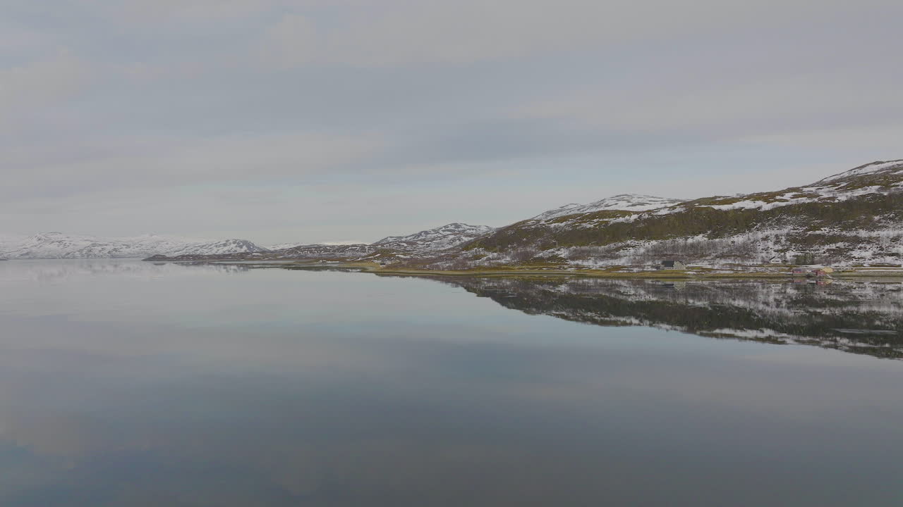 склоны холмов побережья норвегии, отражающиеся в гладкой воде фьорда, аэрофотосъемка