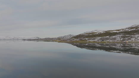 laderas de las colinas de la costa de noruega que se reflejan en el agua suave del fiordo, antena