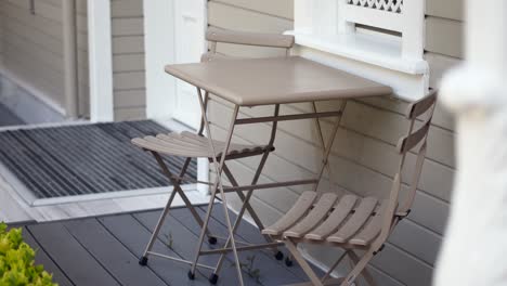 a small table and two chairs on a front porch