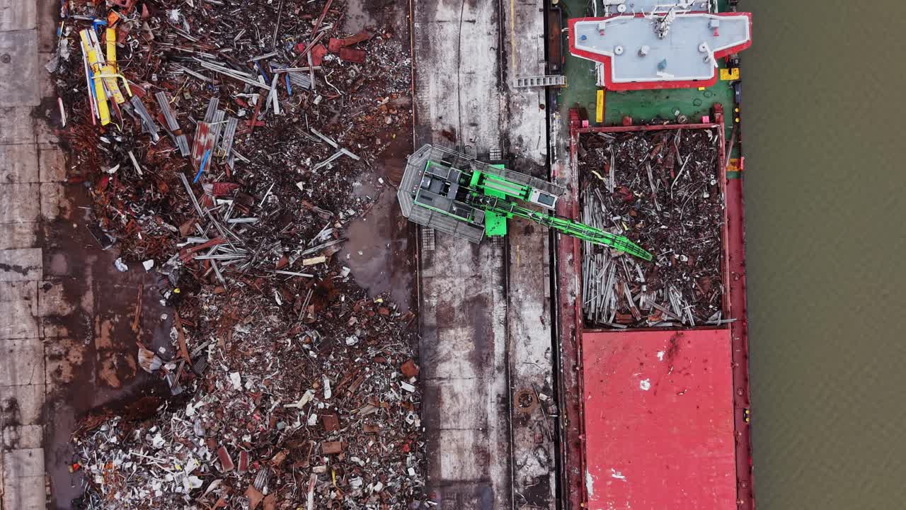 Operazione in cantiere navale con una gru e una nave da carico in azione.