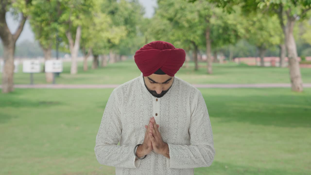 Uomo indiano sikh religioso che prega Dio nel parco