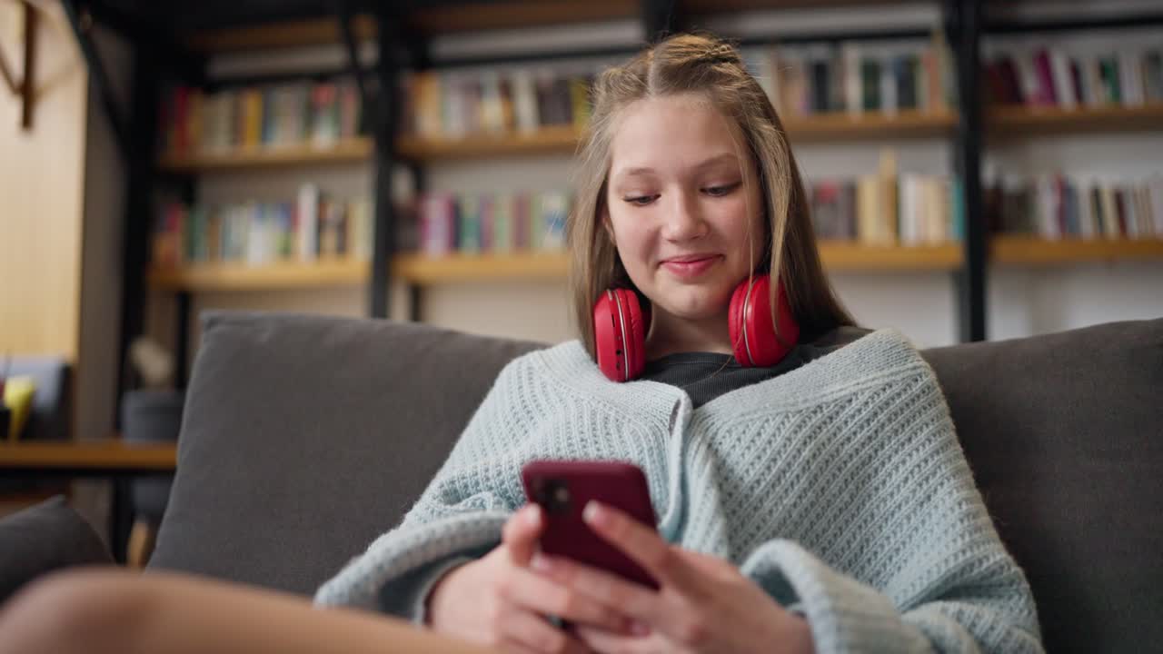 Teenage girl using smartphone in a library