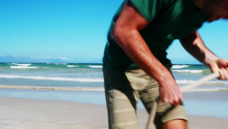 Family-playing-tug-of-war-at-the-beach