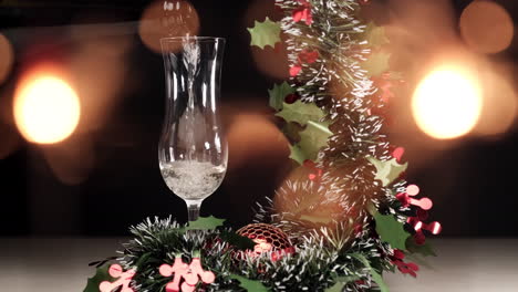 pouring champagne in flute with christmas garland decoration and sparklers fireworks lights