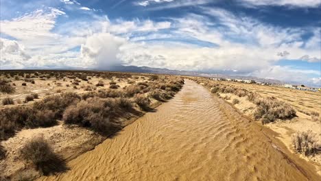 Lecho-De-Río-Generalmente-Seco-De-Cache-Creek-En-El-Desierto-De-Mojave-Que-Fluye-Con-Agua-Después-De-Una-Tormenta---Sobrevuelo-Aéreo