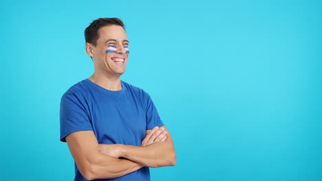 happy man with salvadoran flag painted on face looking away
