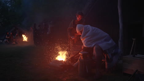 medieval blacksmith at work by the campfire