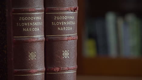 Close-up-of-two-vertically-put-old-books-in-red-covers-about-history-of-slovene-nation
