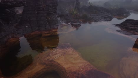 Drone-Volando-Hacia-Atrás-Revelando-Jacuzzis-Naturales-Rodeados-De-Niebla-De-Roraima-Tepui