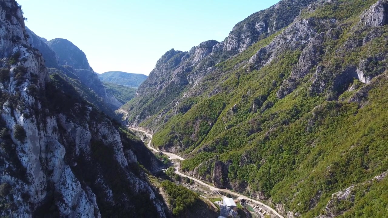 Vista aerea di una strada sterrata all'interno di una valle nelle montagne albanesi. Paesaggio suggestivo