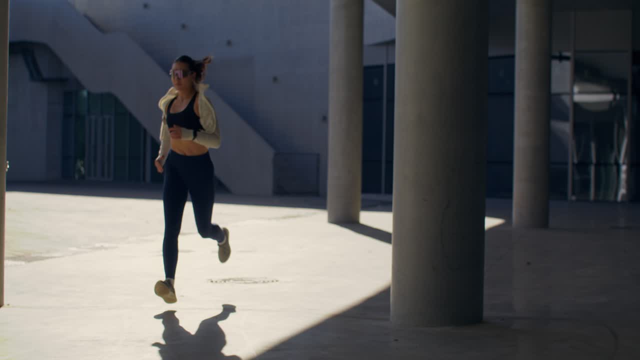 Woman Running Among Columns in Urban Setting