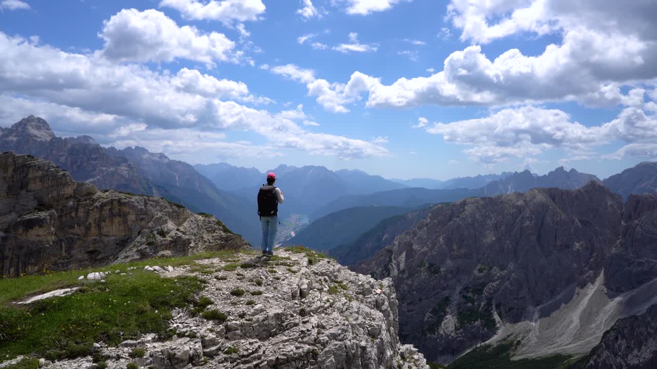 도로미트 알프스 산맥의 정상에 서 있는 하이커 여성.