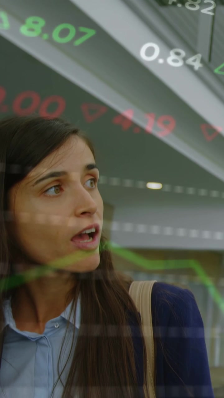 Video verticale: Ticker che scorrono velocemente, mentre una donna si gira, parla, fa una pausa, ingrandisce e visualizza i mercati.