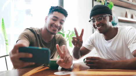 dos hombres jóvenes tomando un selfie mientras toman café