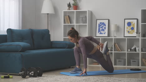 La-Mujer-Está-Haciendo-Ejercicio-Para-Estirar-Los-Músculos-De-Las-Piernas-Entrenando-En-Casa,-Deporte-Y-Estilo-De-Vida-Saludable-Preocupándose-Por-La-Belleza-Del-Cuerpo