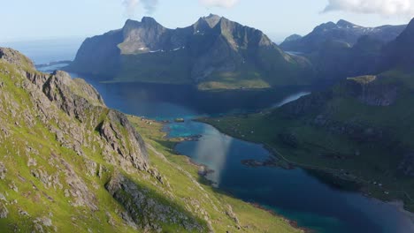 Drone-shot-of-Lofoten-steep-cliffs-and-mountains-rising-from-deep-blue-fjord