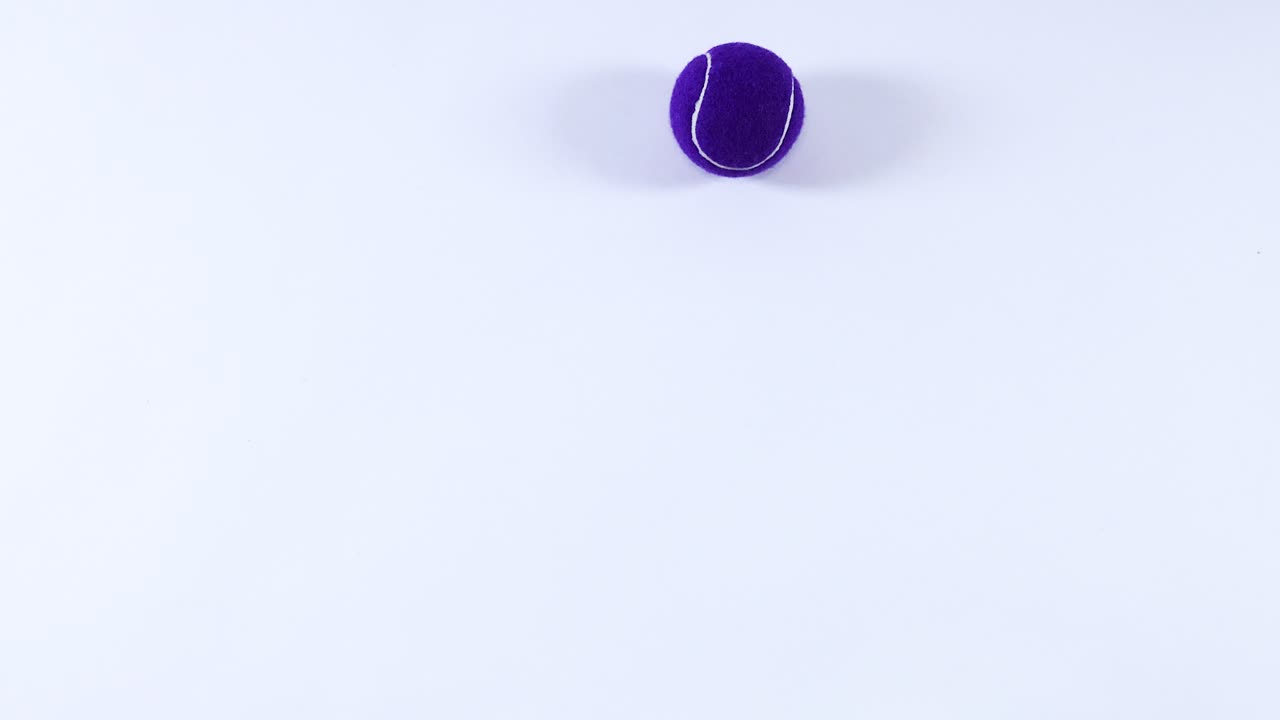 Multiple tennis balls bouncing on a white surface
