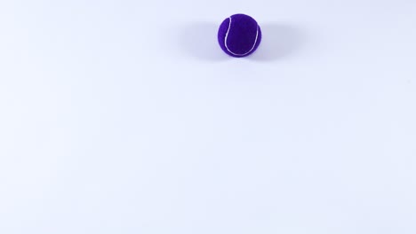 multiple tennis balls bouncing on a white surface