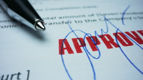 Pen-lying-on-contract.-Document-with-approved-stamp.-Signature-on-contract