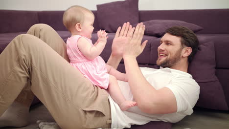 dad with baby playing hands