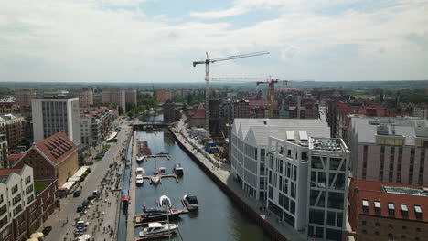 4k aerial flight over vistula river and parking speedboats between modern architecture buildings in old town of gdansk,poland