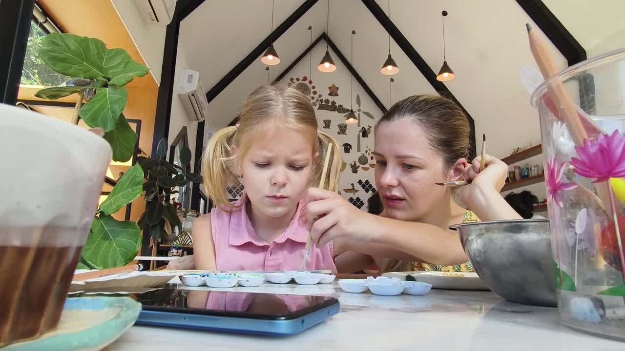 Madre e figlia che dipingono insieme in un caffè