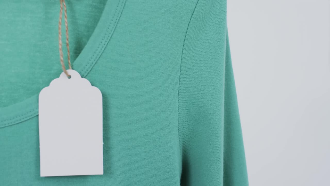 video di maglietta verde con tag e spazio di copia su sfondo bianco
