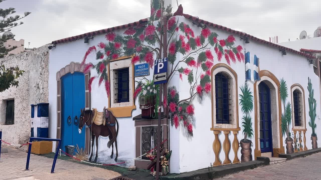Colorful corner house with hand painted walls in Chersonissos, Crete, Greece