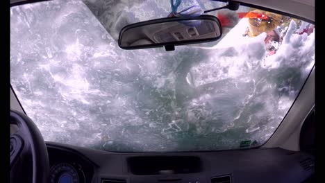 man clearing snow from car 4k