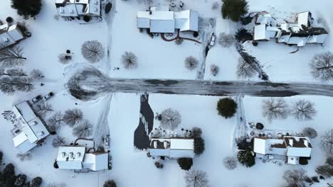 top down aerial of residential neighborhood community cul de sac covered in winter snow and ice