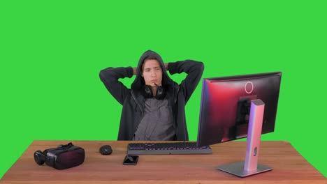 stressed tired out of work hacker looking at pc monitor on a green screen, chroma key
